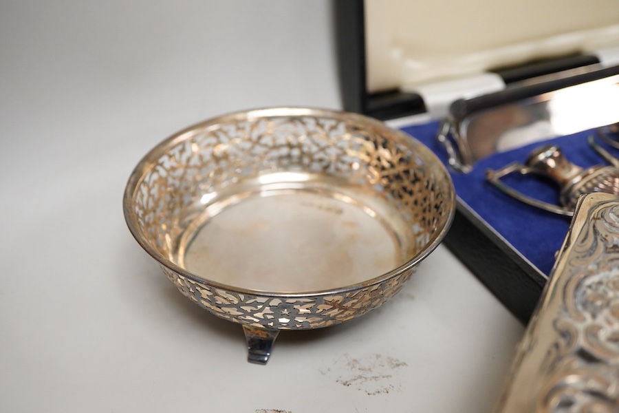 Small silver including a pair of George V pierced silver bonbon dishes, Birmingham, 1915, diameter 97mm, an Edwardian silver mounted glass inkwell, a cased modern silver miniature four piece tea set and tray and a German